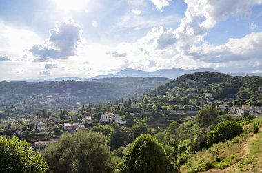 Antik Fransız köyü Saint-Paul-de-Vence yakınlarındaki bir tepede panoramik kırsal manzaralı küçük evler ve güneşli bir yaz gününde Fransa 'nın Provence kentindeki Maritime Alpleri dağları.