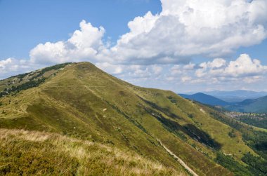 Strymba Dağı yakınlarındaki Karpatlar 'ın manzarası. Yeşil orman çayırı ve mavi bulutlu gökyüzü olan yaz manzarası. Ukrayna