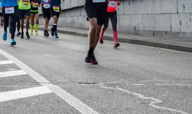 Sonbahar yolunda şehir maratonu koşan sporcular. İnsanların ayaklarına kapanıyorsun. Fitness ve sağlıklı yaşam tarzı konsepti