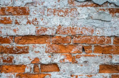 Hasar yüzeyi ve beyaz çatallı sıva parçalarıyla eski kırmızı desenli tuğla duvarın arkaplan görüntüsü