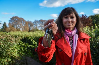 Seçici odaklanma. Esmer bir kadın elinde bir apartman anahtarı tutuyor. Emlakçı yatırımının satış fırsatı kavramı 