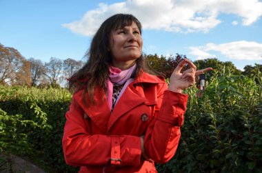 Çekici esmer hayalperest kız gülümsüyor ve anahtarı elinde tutuyor. Gayrimenkul alma kararının tadını çıkarıyor. Gelecek için fikirler ve kavramlar planlar