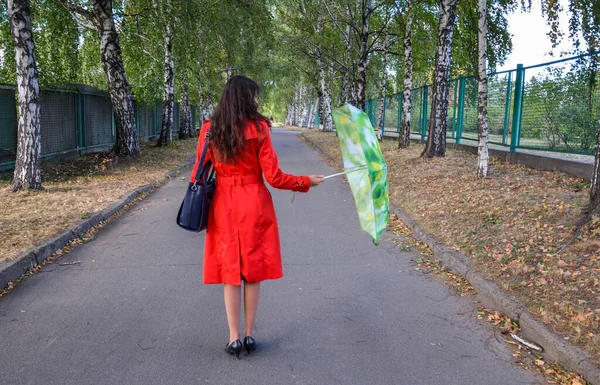 Девушка Брюнетка Красном Пальто Яркими Пуговицами Осеннем Парке Стоит Спиной — стоковое фото