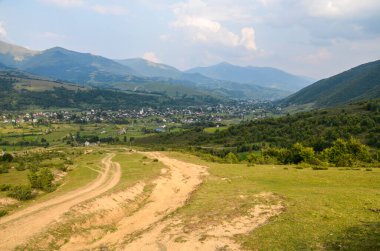 Vadideki dağ sırasının güzel doğa manzarası uzak bir mesafeden kırsal köy. Doğal arkaplan.