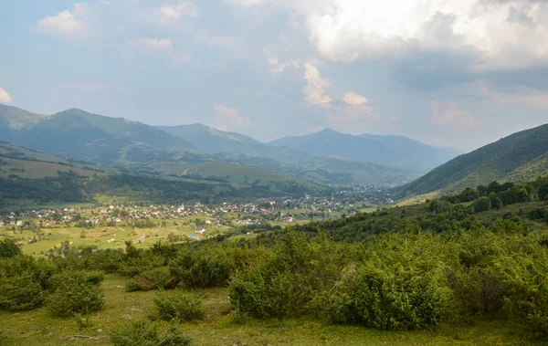 Vadideki dağ sırasının güzel doğa manzarası uzak bir mesafeden kırsal köy. Doğal arkaplan.