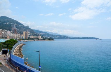 Monako Carlo Prensliği 'nde gemilerle ünlü bir Akdeniz sahili manzarası ve lüks apartman binaları.
