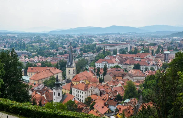 Slovenya 'nın başkenti Ljubljana' nın havadan görünüşü. Kırmızı kiremit çatılı binalar, arka planda dağ sıraları, City Castle Hill 'den görülüyor.