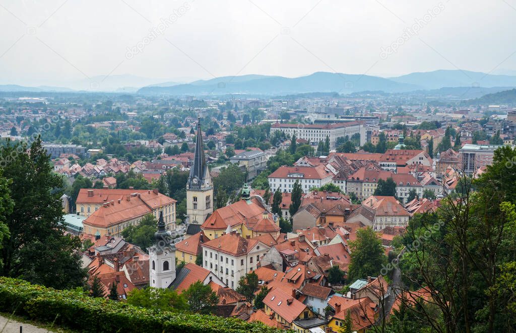 Aerial view of the old city Ljubljana, the capital of Slovenia. Buildings with red tile roofs, mountain range in the background, seen from city castle hill