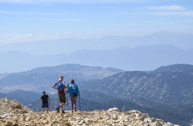 Turist veya arkadaş grubu durdukları yerden Taurus Dağları, Tahtali, Kemer, Türkiye 'ye bakıyorlar