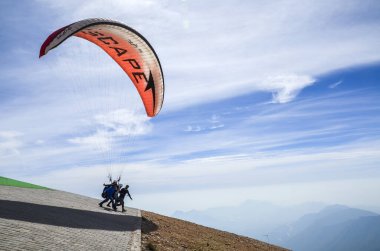 KEMER, TURKEY - 5 EKİM 2018 Kırmızı paraglider Taurus Dağları üzerinde Tahtali Dağı, Türkiye