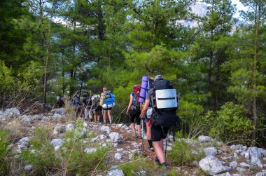 Sırt çantalı bir grup turist Türkiye 'deki Lycian Yolu' nda yürüyor. Seyahat, macera ya da dağlara yolculuk kavramı. Arkadan bak.