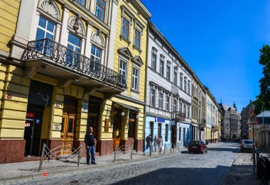LVIV, UKRAINE - 25 Mayıs 2013: Tarihi şehir merkezi Lviv, Ukrayna 'nın eski klasik binaları ile tipik ortaçağ caddesi 