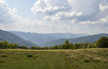 Karpat Dağları 'nın zirveleri bir yaz günü. Mavi gökyüzünün altında, Ukrayna 'da bulutlarla kaplı dağ sıraları.. 
