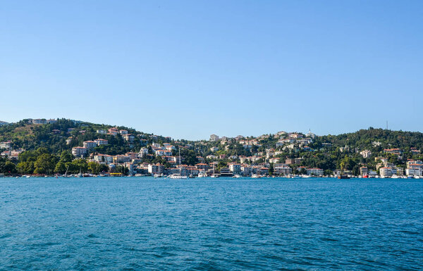 Вид на жилой район, разноцветные дома на набережной и парк со стороны пролива Босфор в Стамбуле, Турция.