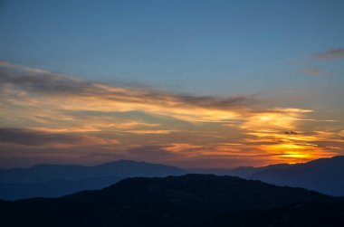 Gün batımında dağ manzarasının panoramik görüntüsü. Dağ siluetleri. Kemer yakınlarındaki Tahtali Dağı 'ndan Taurus Dağları' na, Türkiye