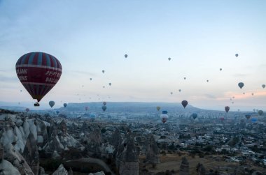 GOREME, TURKEY - 11 Ekim 2018: Vadi üzerinde uçan renkli sıcak hava balonları ve Goreme, Kapadokya, Türkiye yakınlarında peri bacaları olan kaya oluşumları