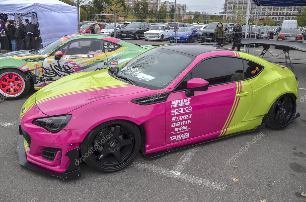 Highly customized Subaru BRZ sports car showcasing a bold and unique two tone paint scheme of vivid lime green and hot pink