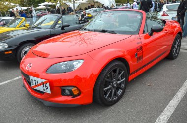 Canlı kırmızı Mazda MX-5 Miata üstü açık üstü açık, mükemmel kullanımıyla ve dengeli performansıyla tanınıyor.