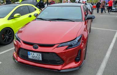 Pürüzsüz Scion TC, parlak kırmızı kaplamalı kompakt spor coupe, siyah çoklu alaşımlı tekerlekler, ve zıt siyah çatı, ona özel, agresif görünüm verir