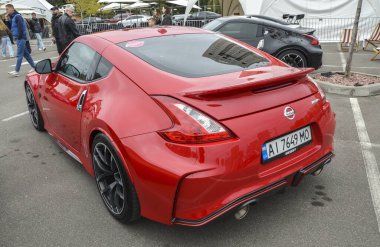 Canlı kırmızı Nissan 370Z Nismo performans odaklı tasarımla modern Japon spor araba performansı ve tasarım özünü yakalar.