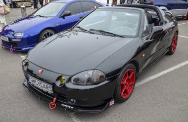 Dinamik siyah Honda CRX Del Sol, açık hava sürüş deneyimini vurgulayan iki koltuklu targa üstü bir roadster.