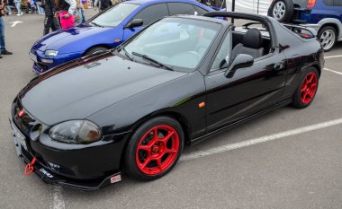 Dinamik siyah Honda CRX Del Sol, açık hava sürüş deneyimini vurgulayan iki koltuklu targa üstü bir roadster.