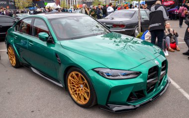 Görsel olarak çarpıcı yeşil BMW M3 G80 performanslı sedan böbrek ızgarası keskin farları ve aerodinamik vücut kiti yüksek performanslı soyağacını vurguluyor.