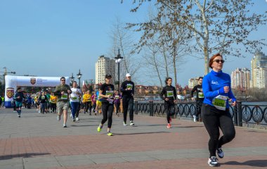 Bir şehrin yarı maratonu başlangıç kemerinin altında başlarken, koşucular güneşli nehir kenarındaki bir güverteyi sular altında bırakıyorlar.