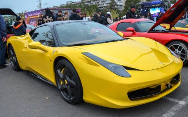 Çarpıcı sarı Ferrari 458 Italia supercar. Gösterişli İtalyan spor arabası, ikonik aerodinamik çizgileri, siyah çatısı ve siyah tekerlekleri, yüksek hız ve lükse sahip.