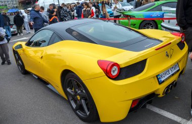Çarpıcı sarı Ferrari 458 Italia supercar. Gösterişli İtalyan spor arabası, ikonik aerodinamik çizgileri, siyah çatısı ve siyah tekerlekleri, yüksek hız ve lükse sahip.