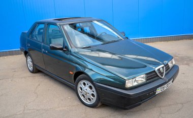 Klasik koyu yeşil Alfa Romeo 155 sedan 1990 'ların Avrupa otomotiv tasarımının özünü yakalıyor
