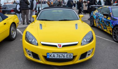 Parlak sarı Satürn Gök Roadster üstü açılabilir kompakt Amerikan özellikleri siyah yumuşak üst ve parlak, spesifik çamurluk menfezleri ve temiz farları olan spor tasarımı.