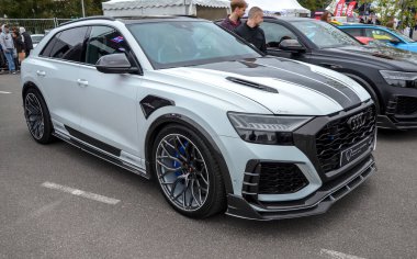 Yüksek özelleştirilmiş beyaz Audi RS Q8 performanslı SUV açık hava otomobil etkinliğinde sergileniyor, agresif ve lüks bir varlık sergiliyor