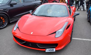 Canlı kırmızı Ferrari 458 Italia süper araba gösterişli İtalyan spor arabası aerodinamik çizgileri ve farları açık hava araba fuarının odak noktasıdır.