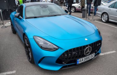 Sersemletici bir mat mavi Mercedes-AMG GT 63 4 kapılı Coupe bir açık hava araba etkinliğinde sergileniyor, lüks ve yüksek performanslı bir karışım yayıyor