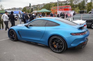 Sersemletici bir mat mavi Mercedes-AMG GT 63 4 kapılı Coupe bir açık hava araba etkinliğinde sergileniyor, lüks ve yüksek performanslı bir karışım yayıyor