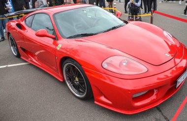 Canlı kırmızı Ferrari 360 Modena, ikonik İtalyan süper arabası gösterişli, aerodinamik çizgiler, berrak farlar ve sportif bir arka spoiler içeriyor.