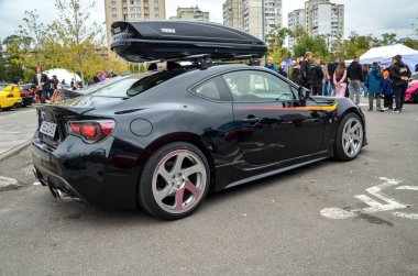 Özelleştirilmiş siyah Toyota GT86 spor coupe, gözenekli tasarımı ve modifiye edilmiş araçların pratik ama performans odaklı doğasını ön plana çıkarıyor