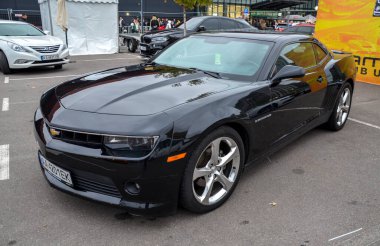 Parlak siyah Chevrolet Camaro beşinci nesil güçlü Amerikan kaslı arabası agresif ön ızgarası, kendine özgü modern performans yansıtan farları var.