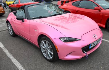 Benzersiz ve göz alıcı pembe Mazda MX-5 Miata üstü açık üstü açık, özgün spor arabaları ve özel araçları beğenenler için çekici.