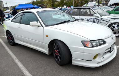 Beyaz Toyota Sprinter Trueno AE111 nesil spor coupe, JDM klasiği dengeli performansı ve gösterişli tasarımı ile bilinir, modifiye edilmiş ve sportif bir estetik sergiler