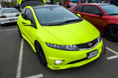Canlı olarak kişiselleştirilmiş kireç yeşili Honda Civic R FN2 tipi hatchback, siyah çatılı ve pazar sonrası tekerlekleriyle modern spor kompaktlarının hayranlarına çekici geliyor.