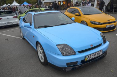 Açık mavi Honda Prelude 5 kuşak klasik JDM spor arabası, gösterişli tasarımı ve çekici tutuşu ile tanınıyor, kişisel ve temiz bir estetik sergiliyor