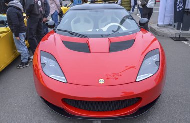Çarpıcı kırmızı Lotus Evora spor arabası, egzotik İngiliz orta motor coupe hafif tasarımı, çevik kullanımı ve sürücü odaklı performansı ile ünlüdür.