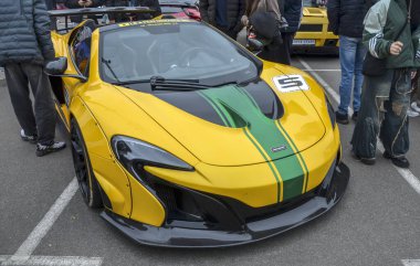 Yeşil yarış şeritli çarpıcı sarı McLaren 650S Spider supercar. Çarpıcı varlık ve tasarım otomotiv lüksü ve mühendisliğinin doruk noktasını temsil ediyor.