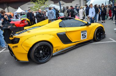 Yeşil yarış şeritli çarpıcı sarı McLaren 650S Spider supercar. Çarpıcı varlık ve tasarım otomotiv lüksü ve mühendisliğinin doruk noktasını temsil ediyor.