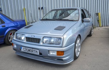 Klasik açık mavi Ford Sierra RS Cosworth sedan sembolik Avrupa performans otomobili, rali mirası ile tanınıyor ve koleksiyoncuların ürünlerinden son derece aranıyor