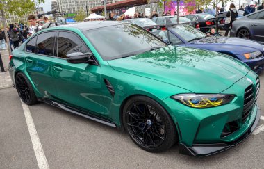 Çarpıcı yeşil BMW M3 (G80) modern Alman yüksek performans aracı, agresif stili, güçlü mühendisliği ve lüks spor yetenekleri ile ünlüdür.