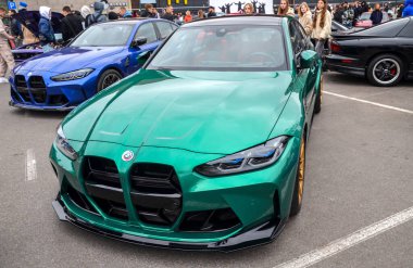 Çarpıcı yeşil BMW M3 (G80) modern Alman yüksek performans aracı, agresif stili, güçlü mühendisliği ve lüks spor yetenekleri ile ünlüdür.