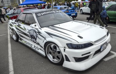 Güçlü modifiye edilmiş beyaz Toyota Mark II popüler orta boy Japon sedanı güvenilirliği, performansı ve geniş ayarlama potansiyeli ile ödüllendirildi.